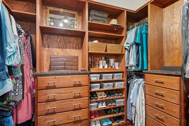a view of walk in closet with clothes and shoes