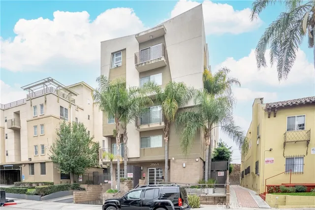 a front view of a building with palm trees