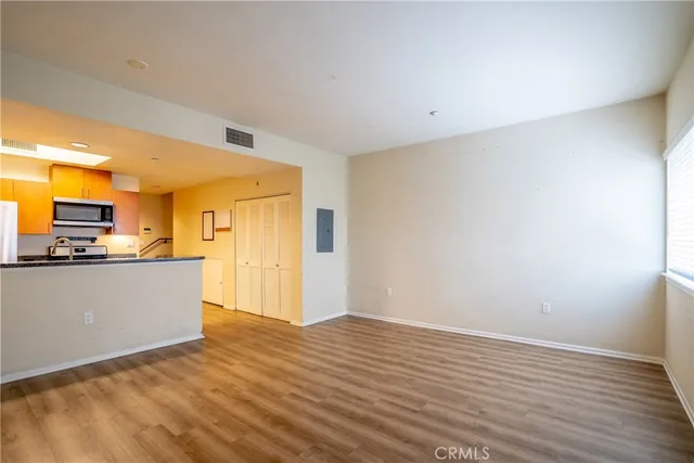 a view of a kitchen with wooden floor and a refrigerator