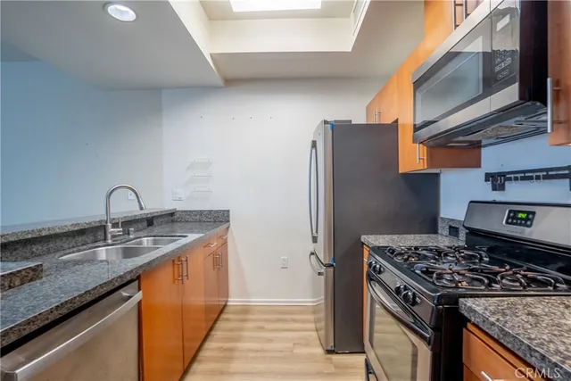 a kitchen with stainless steel appliances granite countertop a sink stove and refrigerator
