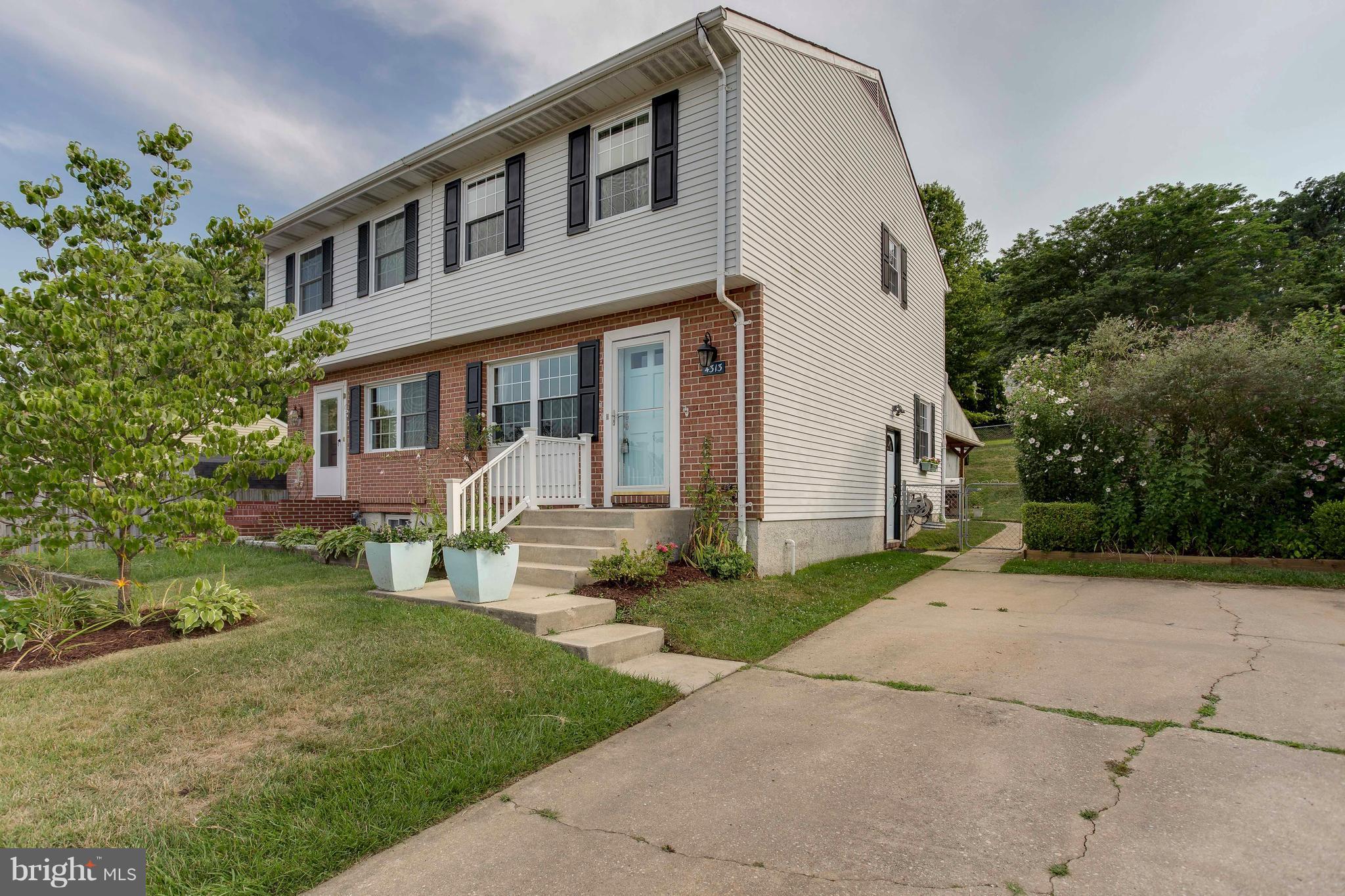 a front view of a house with a yard and potted plants