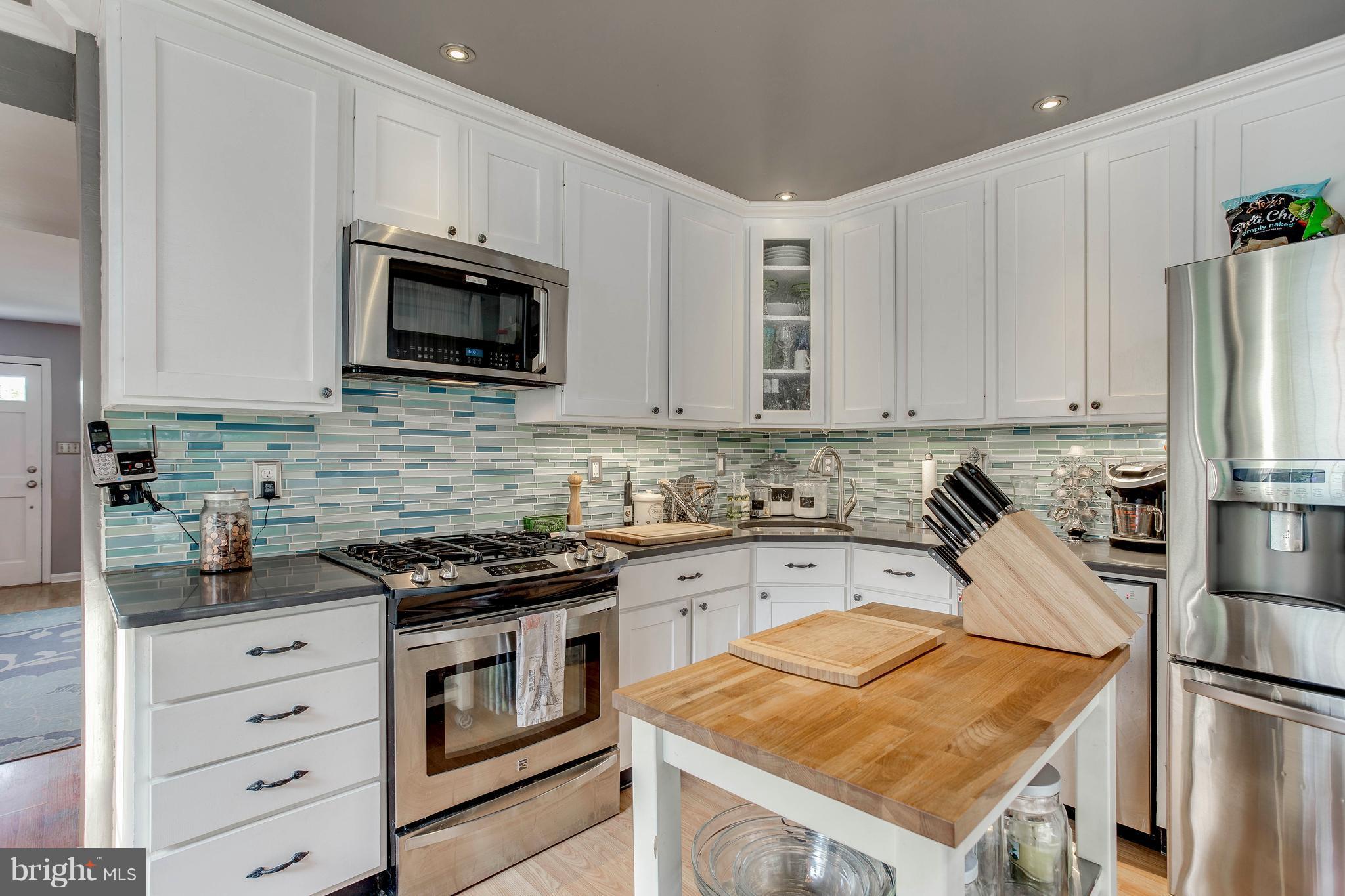 4313 Slater Avenue Baltimore, MD 21236 - Photo 11 of 29 a kitchen with stainless steel appliances granite countertop a stove top oven a sink and cabinets