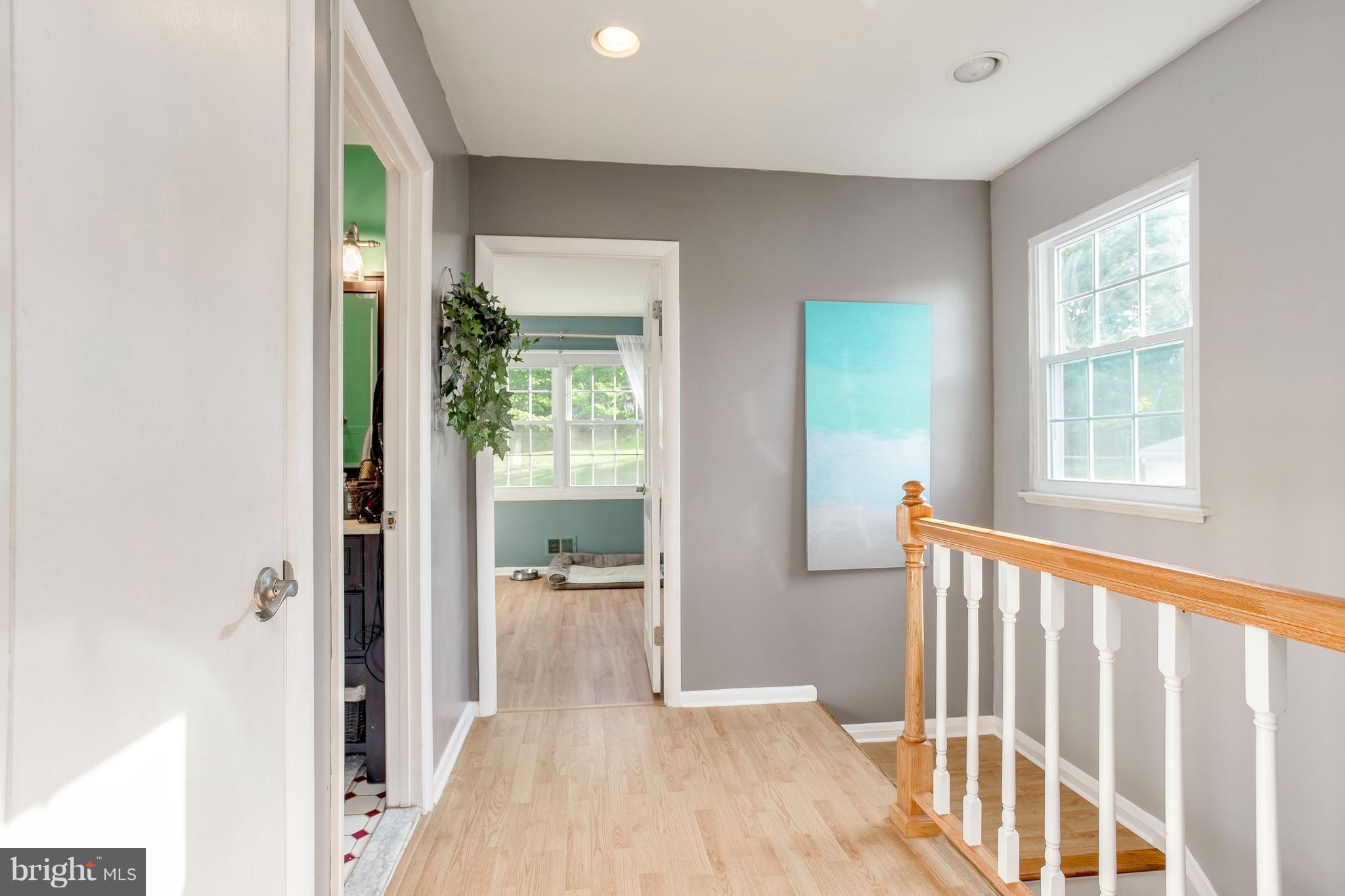 4313 Slater Avenue Baltimore, MD 21236 - Photo 17 of 29 a view of a hallway with wooden floor and a living room