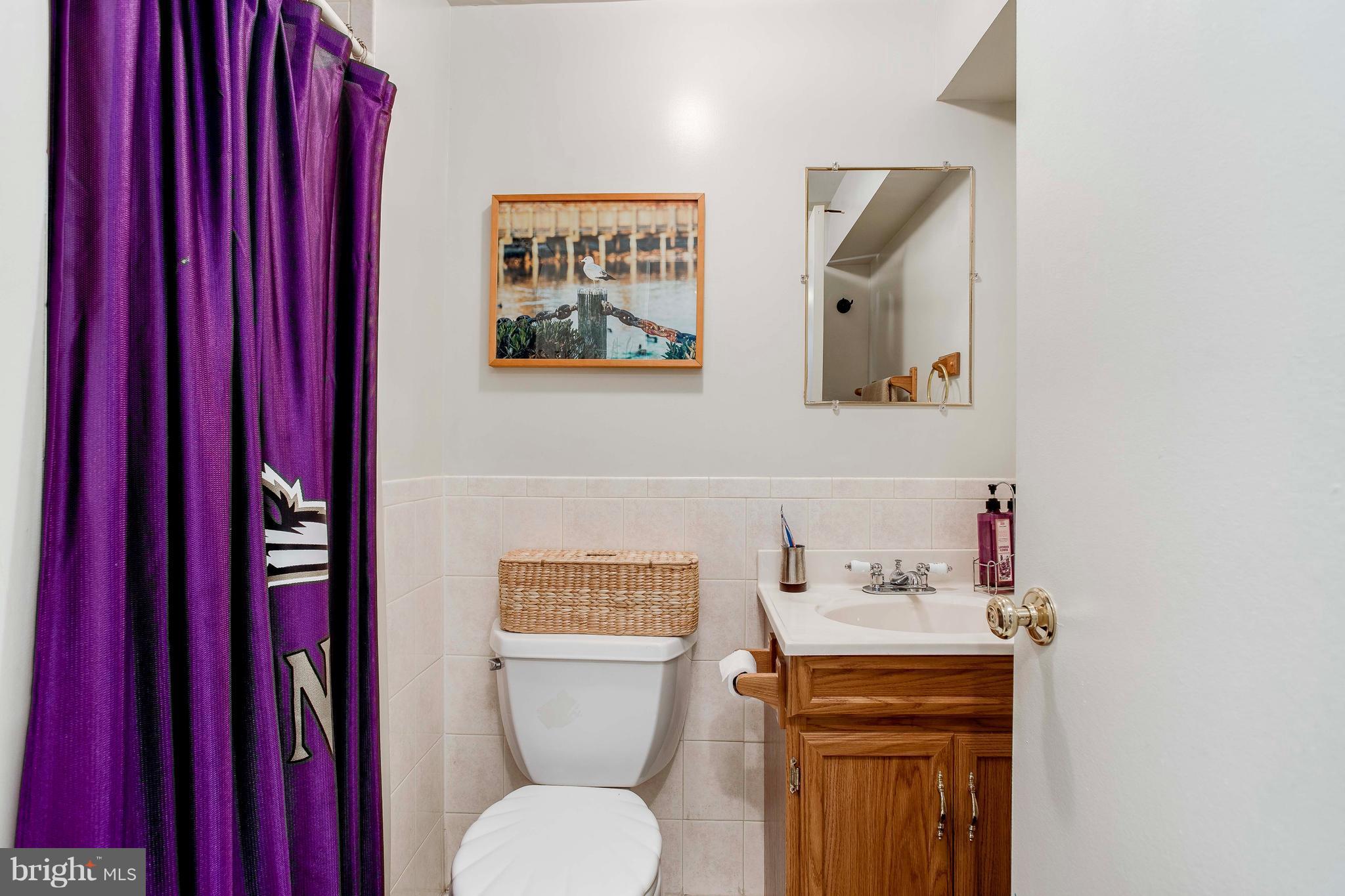 4313 Slater Avenue Baltimore, MD 21236 - Photo 25 of 29 a bathroom with a toilet a sink and wooden floor
