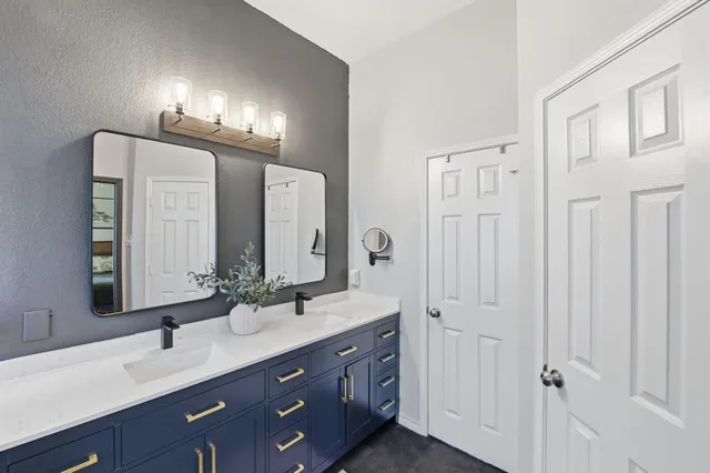 a bathroom with double vanity and a mirror