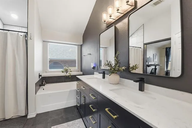 a bathroom with a tub a sink and a mirror