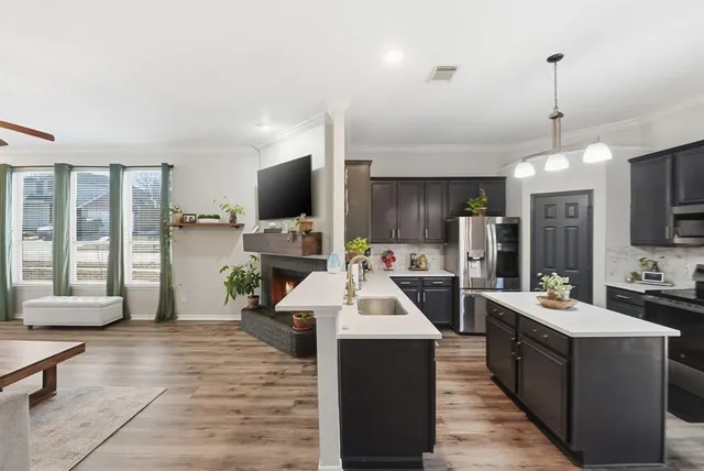 a large kitchen with kitchen island a sink a counter space and stainless steel appliances