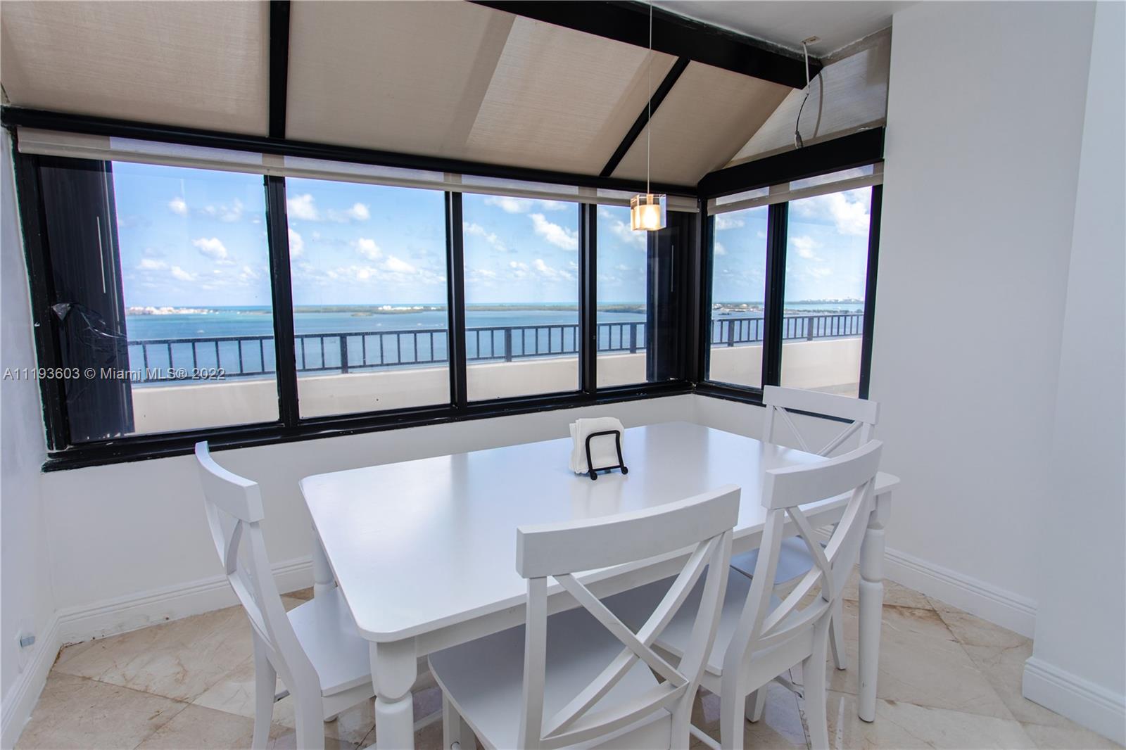 520 Brickell Key Drive, Unit PH03 Miami, FL 33131 - Photo 15 of 75 a dining room with furniture and window