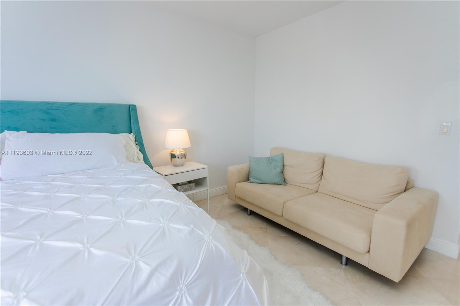 520 Brickell Key Drive, Unit PH03 Miami, FL 33131 - Photo 25 of 75 a spacious bedroom with a bed and a couch