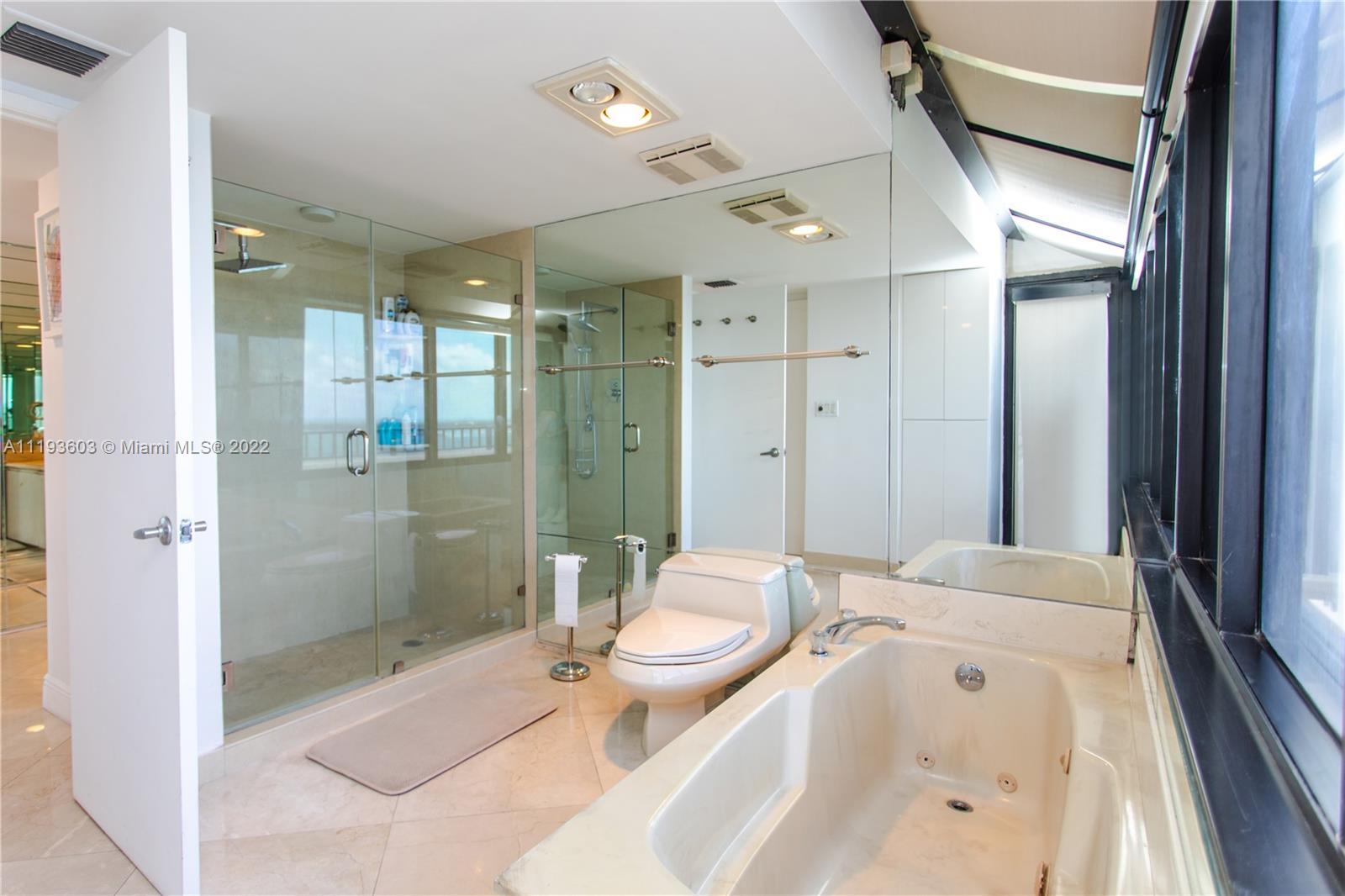 520 Brickell Key Drive, Unit PH03 Miami, FL 33131 - Photo 49 of 75 a spacious bathroom with a sink a toilet a mirror and shower