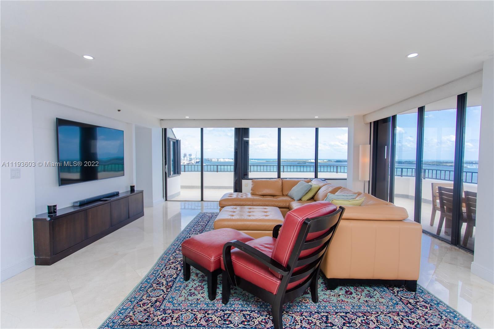 520 Brickell Key Drive, Unit PH03 Miami, FL 33131 - Photo 6 of 75 a living room with furniture a flat screen tv and a large window
