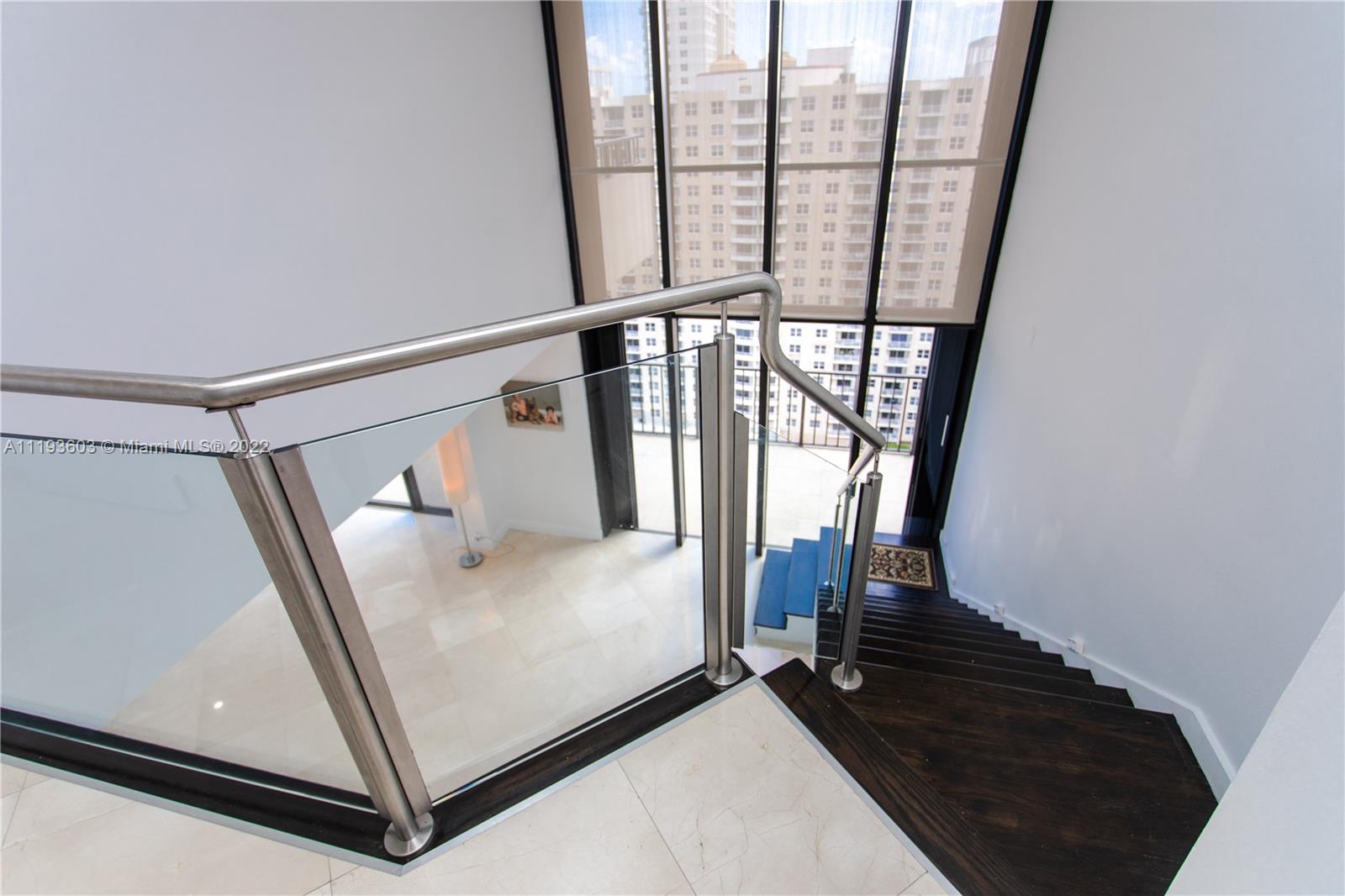520 Brickell Key Drive, Unit PH03 Miami, FL 33131 - Photo 62 of 75 a view of a balcony with wooden floor and white walls