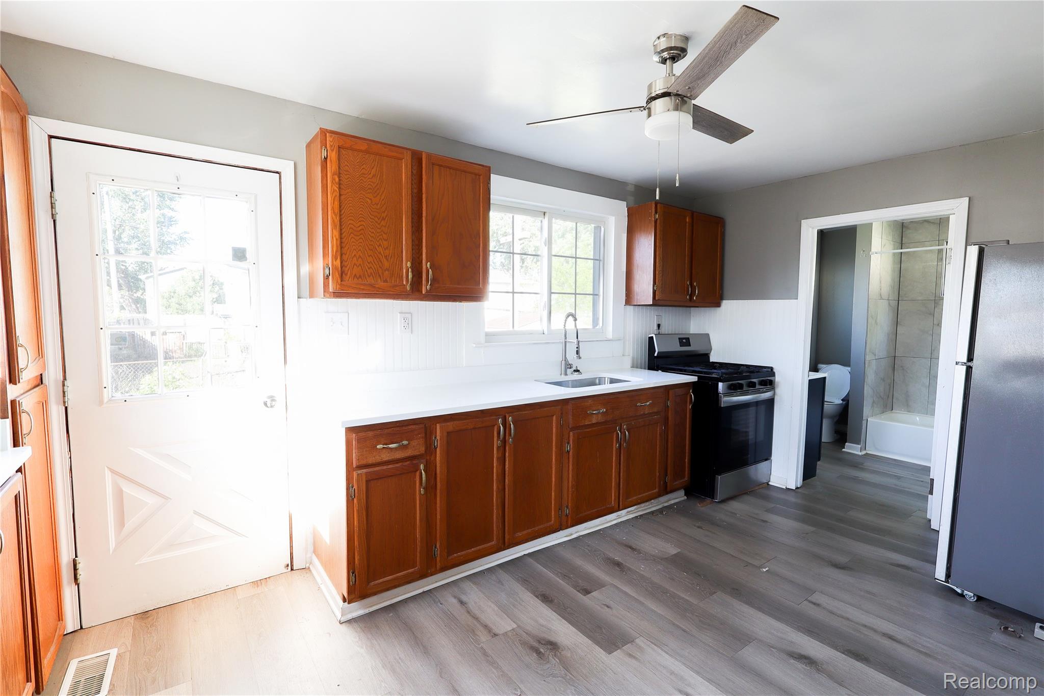 3319 Lakeview Street Monroe, MI 48162 - Photo 10 of 21 Kitchen featuring wood-finish cabinetry, white countertops, a white subway tile backsplash, and wood-finish flooring
