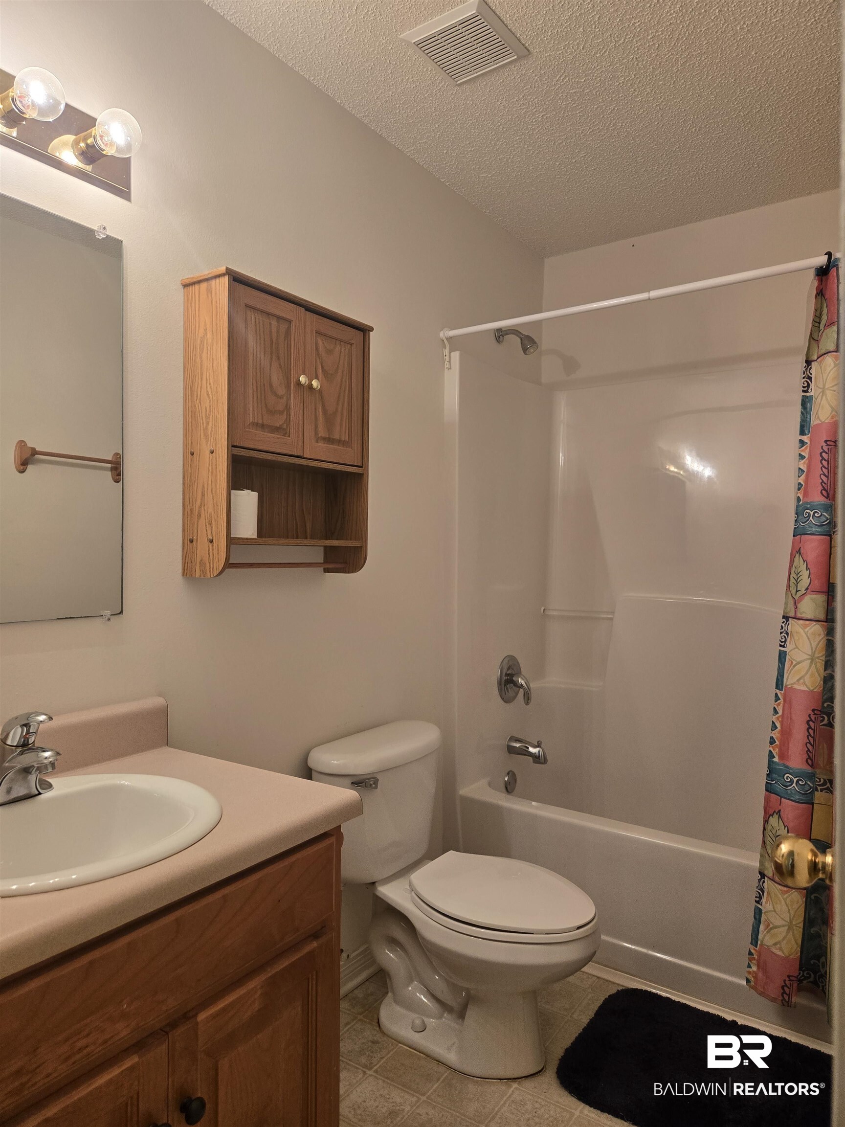 2554 Riverside Drive Mobile, AL 36605 - Photo 21 of 43 Full bath with shower / bath combo, a textured ceiling, vanity, and light tile patterned floors