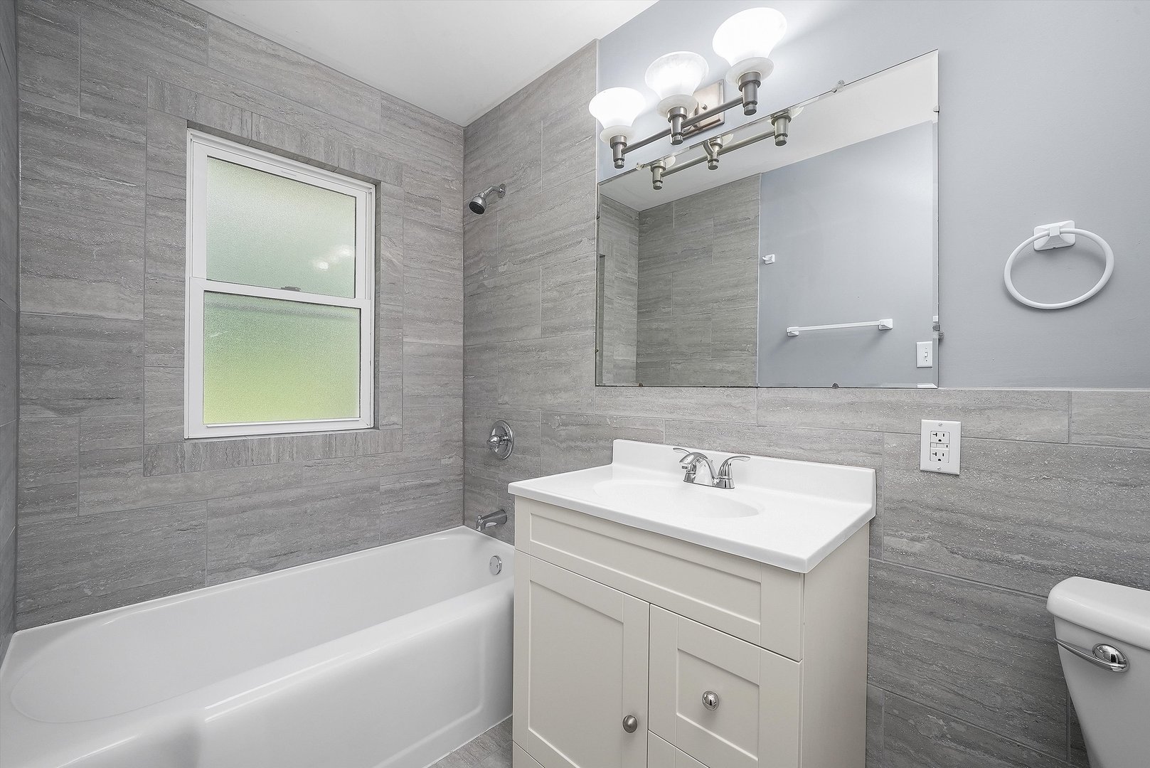 224 South State Street Lockport, IL 60441 - Photo 6 of 28 a bathroom with a sink a toilet a mirror a bathtub and shower