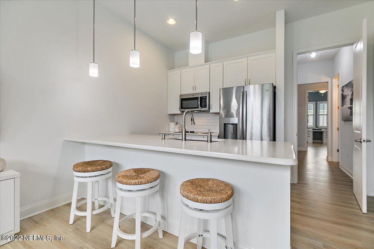 27 Red Twig Way St. Augustine, FL 32092 - Photo 28 of 47 a kitchen with stainless steel appliances granite countertop a sink a stove a refrigerator and white cabinets with wooden floor