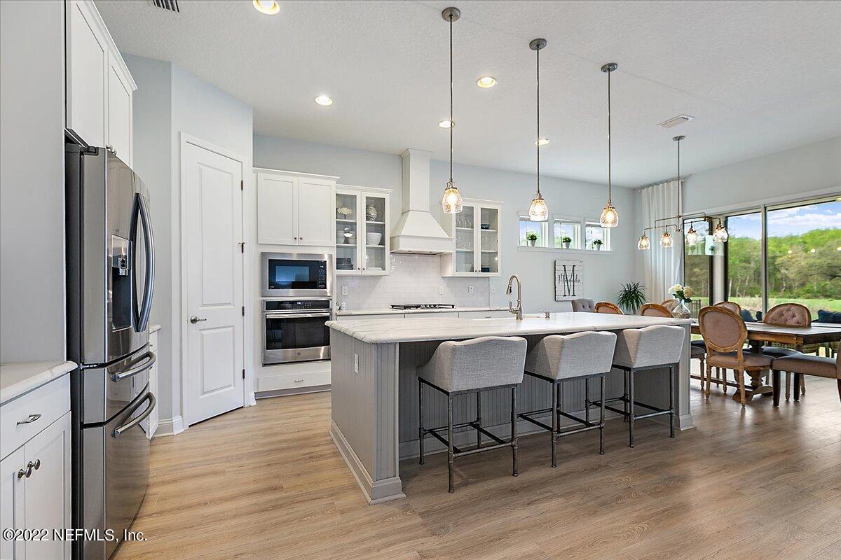 27 Red Twig Way St. Augustine, FL 32092 - Photo 6 of 47 a kitchen with stainless steel appliances granite countertop a table chairs stove and refrigerator