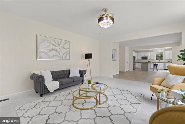 a living room with furniture and kitchen view