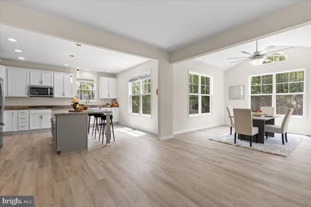 a kitchen with stainless steel appliances wooden floors and dining table