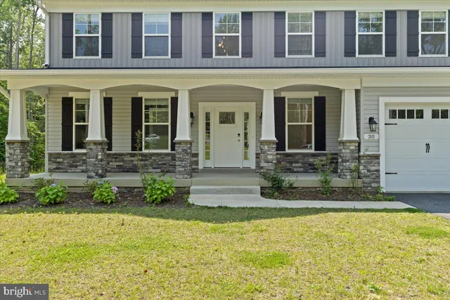 front view of a brick house with a yard