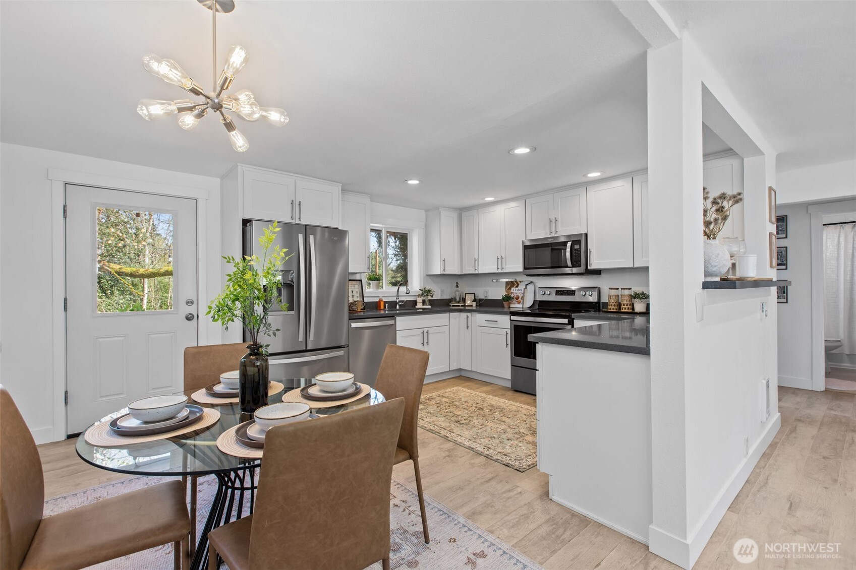 2018 Northeast 97th Street Seattle, WA 98115 - Photo 10 of 39 a kitchen with a refrigerator a stove a sink a dining table and chairs with wooden floor