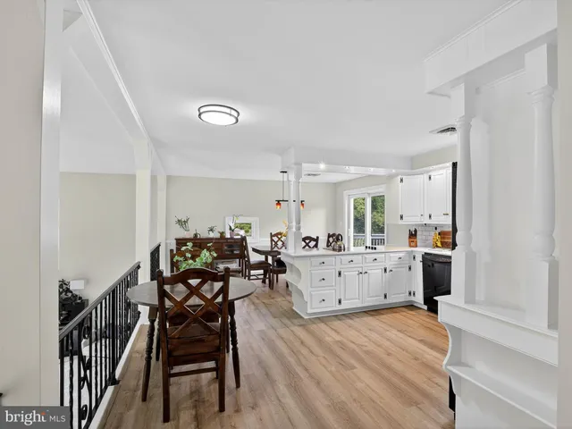 a dining room with furniture potted plants and wooden floor