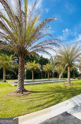 a view of a fountain in front of a house with a big yard