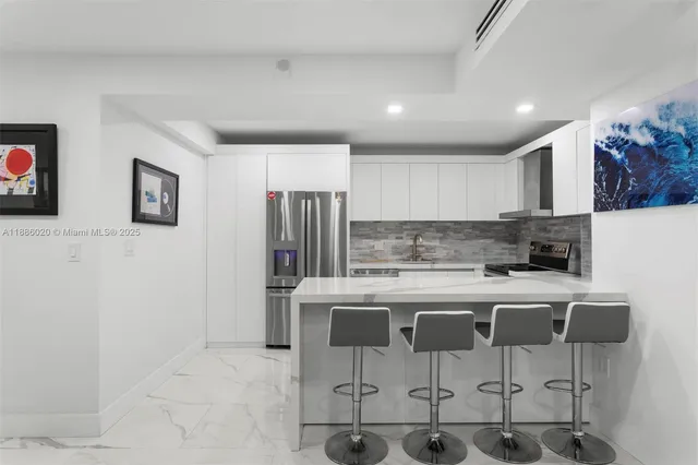 a kitchen with stainless steel appliances granite countertop a refrigerator and a stove top oven