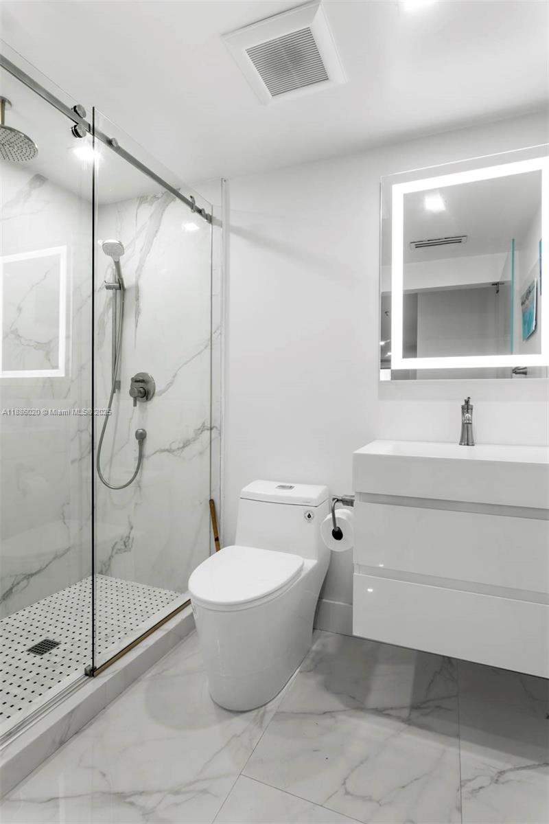 5001 Collins Avenue, Unit 8C Miami Beach, FL 33140 - Photo 17 of 27 a bathroom with a granite countertop sink toilet and shower