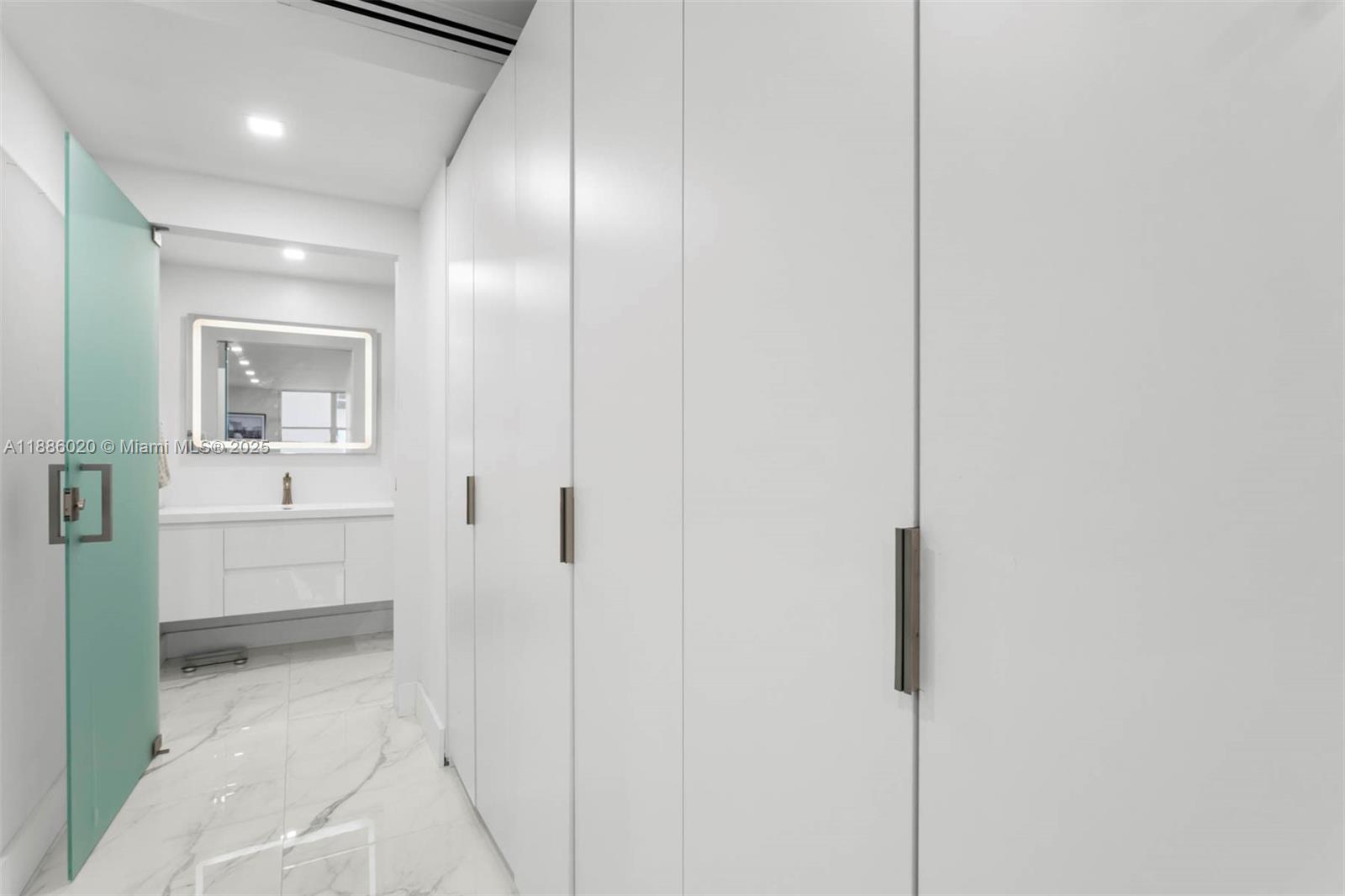 5001 Collins Avenue, Unit 8C Miami Beach, FL 33140 - Photo 22 of 27 a bathroom with a sink and mirror