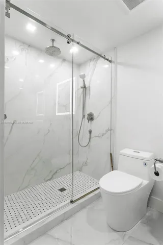 a bathroom with a toilet and a shower