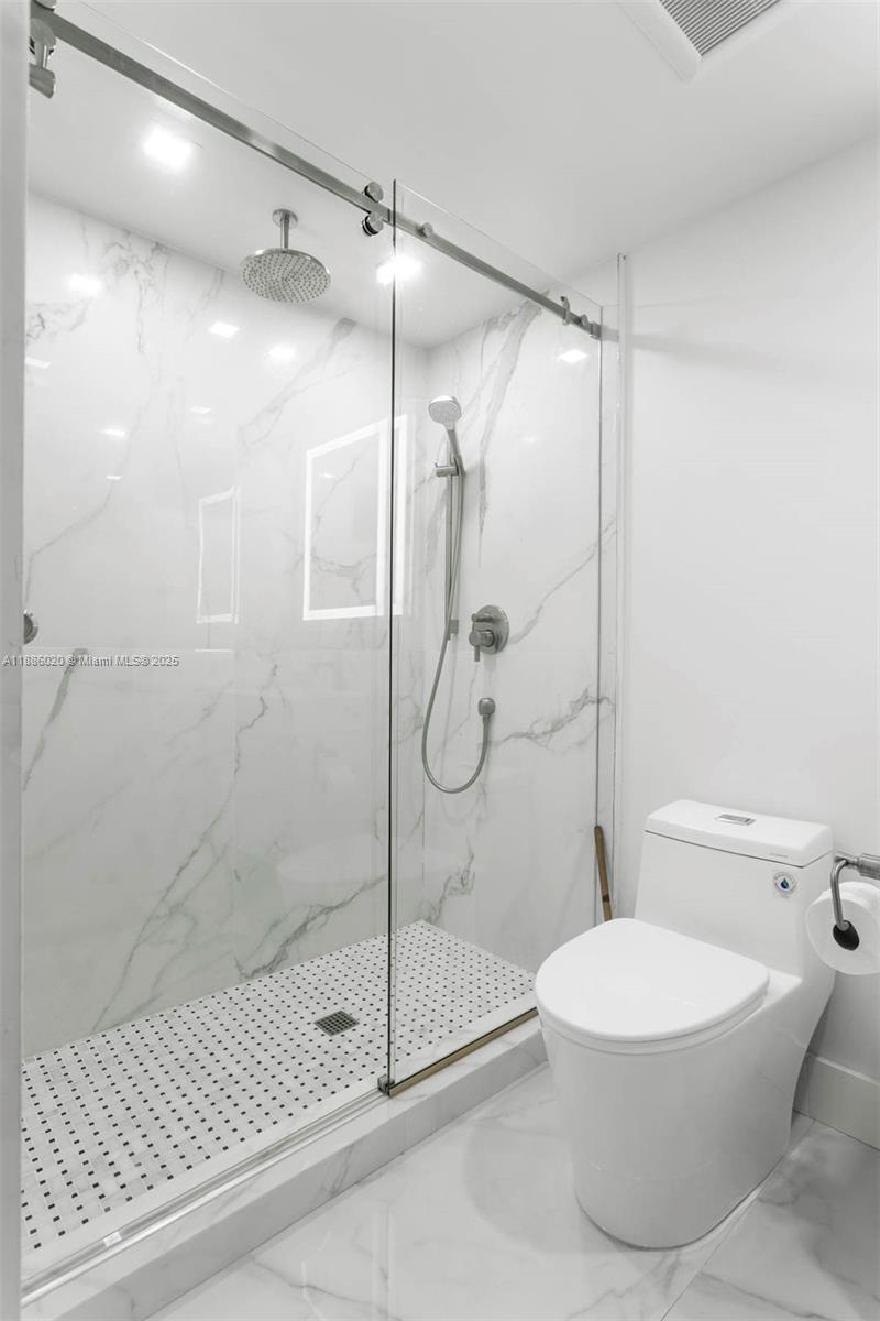 5001 Collins Avenue, Unit 8C Miami Beach, FL 33140 - Photo 23 of 27 a bathroom with a toilet and a shower