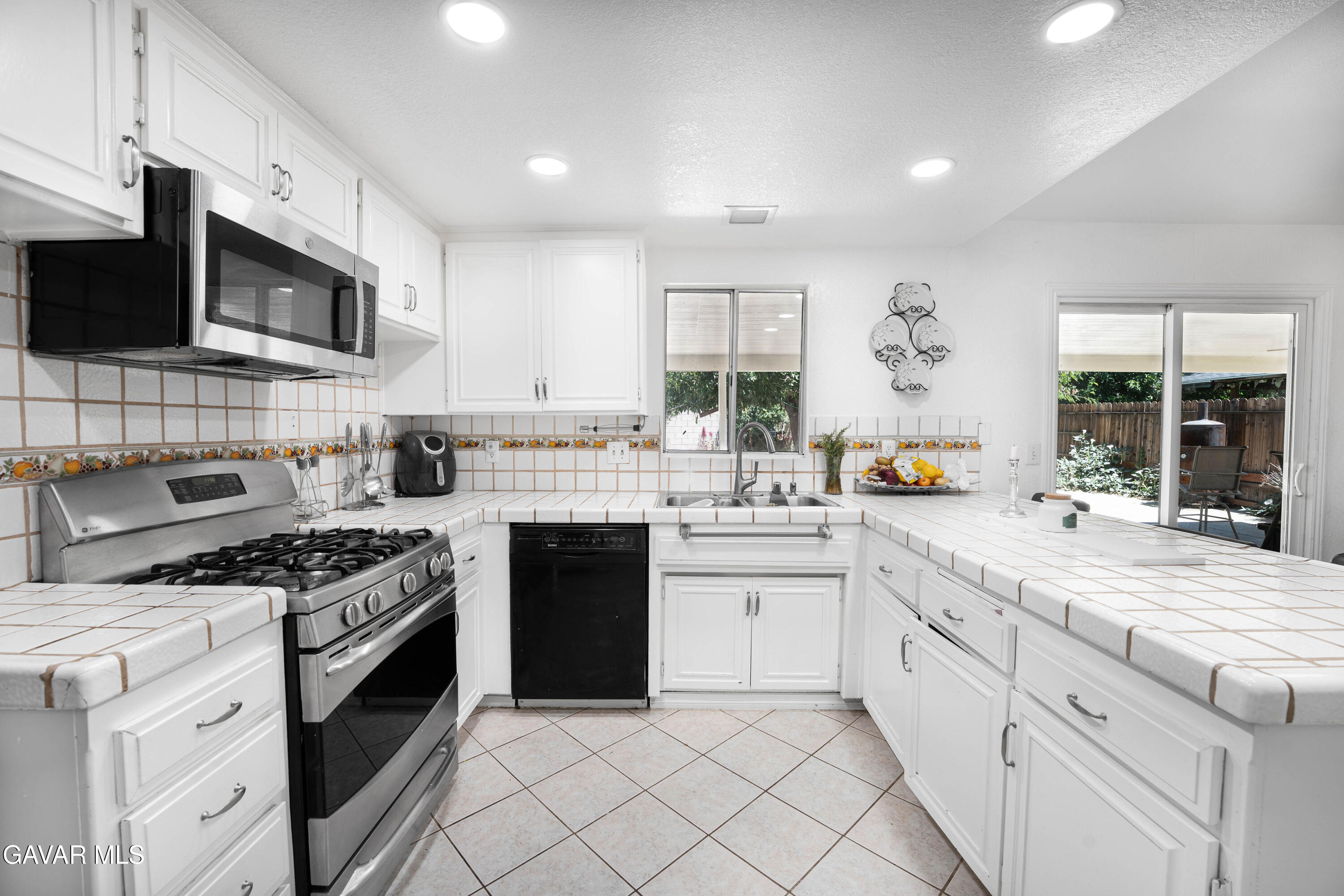 5009 East Ave R 11 Palmdale, CA 93552 - Photo 10 of 23 a kitchen with stainless steel appliances granite countertop a stove a sink and a microwave