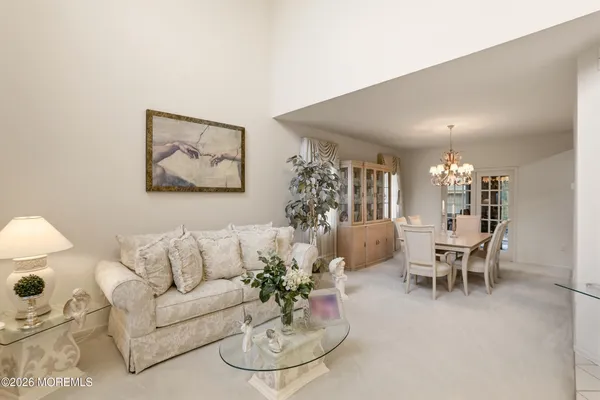 a view of a dining room with furniture a chandelier and wooden floor