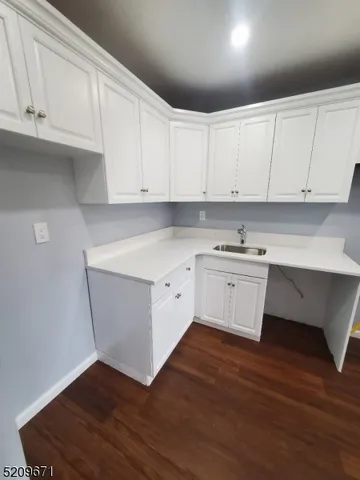 a kitchen with granite countertop white cabinets and white appliances