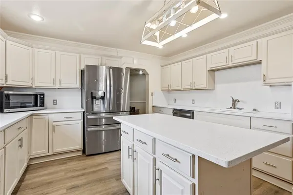 a kitchen with appliances a sink and cabinets