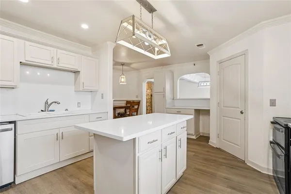 a kitchen with a sink a counter top space and stainless steel appliances