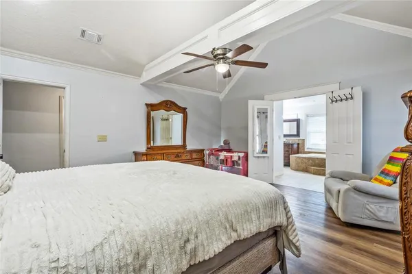 a spacious bedroom with a bed a couch and dresser