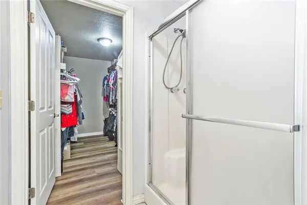 a view of a hallway with wooden floor and windows