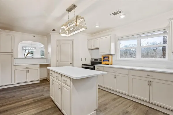 a kitchen that has a sink a stove and cabinets