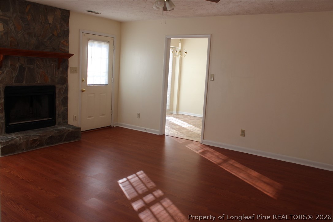 7805 Gallant Ridge Drive Fayetteville, NC 28314 - Photo 23 of 25 an empty room with wooden floor fireplace and windows