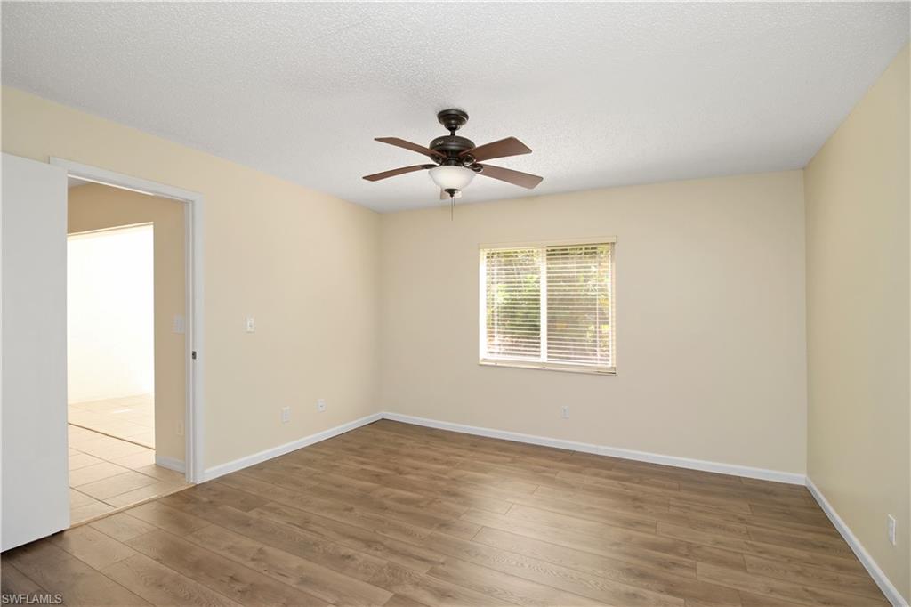 3471 County Barn Road, Unit F103 Naples, FL 34112 - Photo 11 of 27 wooden floor in an empty room with a window