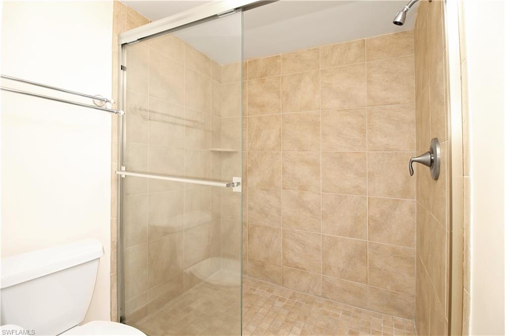 3471 County Barn Road, Unit F103 Naples, FL 34112 - Photo 14 of 27 a bathroom with a shower and a toilet