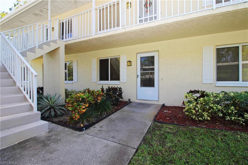 3471 County Barn Road, Unit F103 Naples, FL 34112 - Photo 20 of 27 front view of a house with a small yard