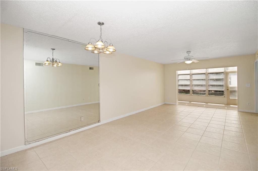 3471 County Barn Road, Unit F103 Naples, FL 34112 - Photo 2 of 27 wooden floor in an empty room with a window