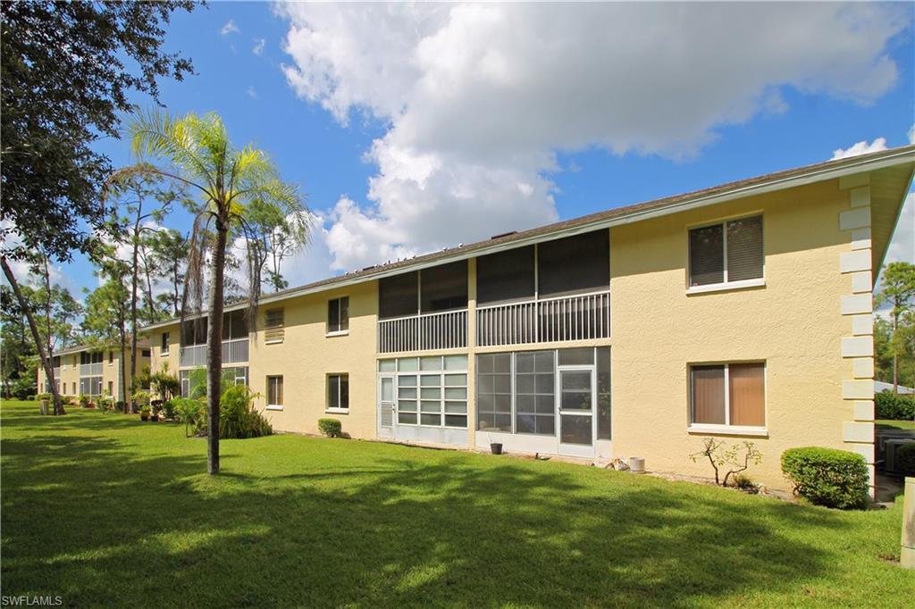 3471 County Barn Road, Unit F103 Naples, FL 34112 - Photo 21 of 27 a front view of a house with a yard