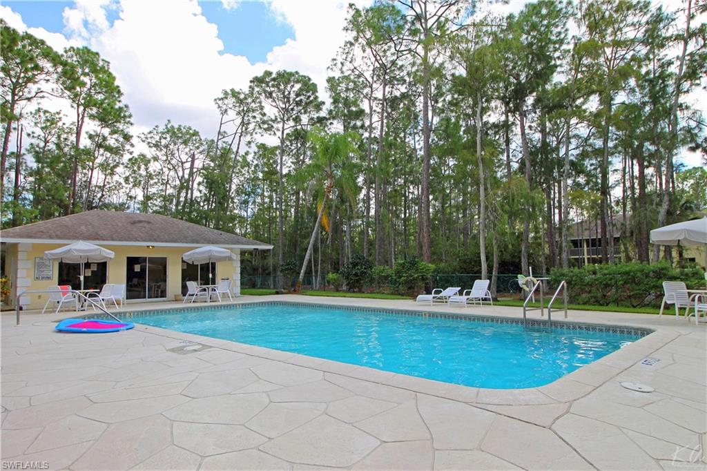 3471 County Barn Road, Unit F103 Naples, FL 34112 - Photo 24 of 27 a swimming pool with outdoor seating and yard