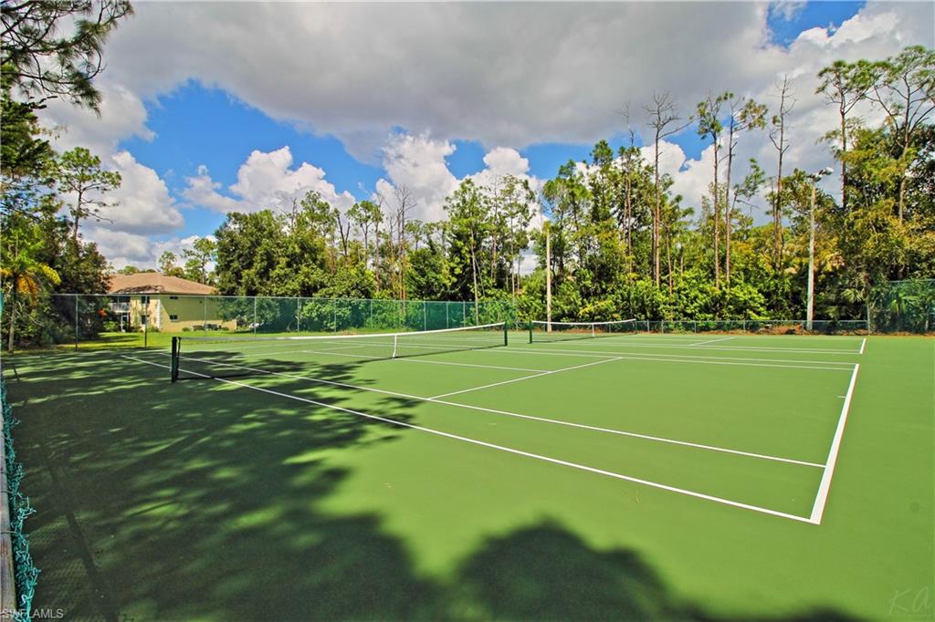 3471 County Barn Road, Unit F103 Naples, FL 34112 - Photo 27 of 27 a view of a tennis ground with large trees