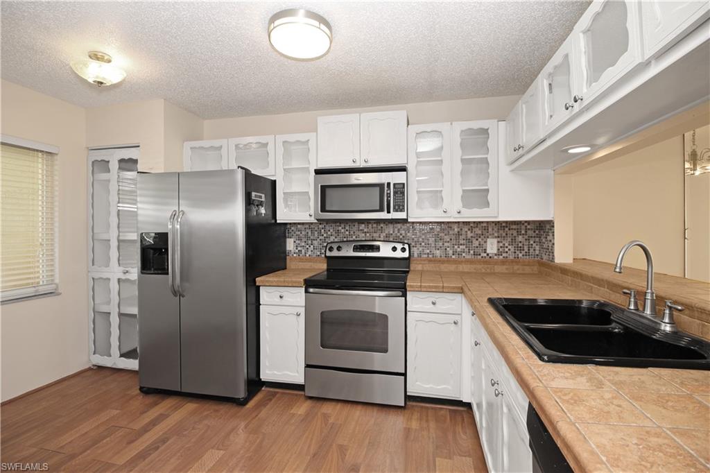 3471 County Barn Road, Unit F103 Naples, FL 34112 - Photo 7 of 27 a kitchen with a sink stove and refrigerator