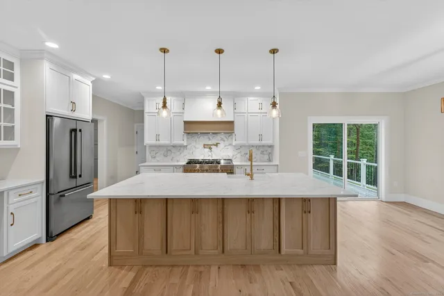 a kitchen with stainless steel appliances granite countertop a kitchen island a stove a sink a center island and cabinets